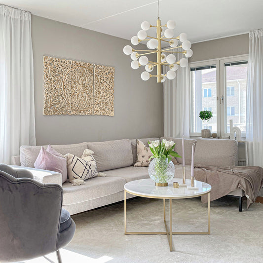 Cosmos taklampe er en moderne pendel lysekrone laget i matt messing og har 24stk runde kupler i opal glass, hengende i en nydelig stue - Aneta belysning