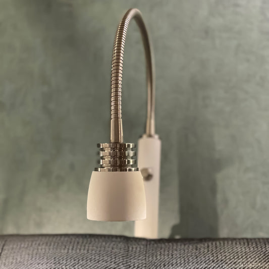 Interiørbilde av Eketorp sengelampe til montering på gavl, laget i hvit metall og stål med justerbar arm og integrert LED-lys - Aneta belysning