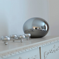 Globus bordlampe laget i speil sotet glass plassert på en skjenk i stuen, diameter 24cm - Aneta belysning