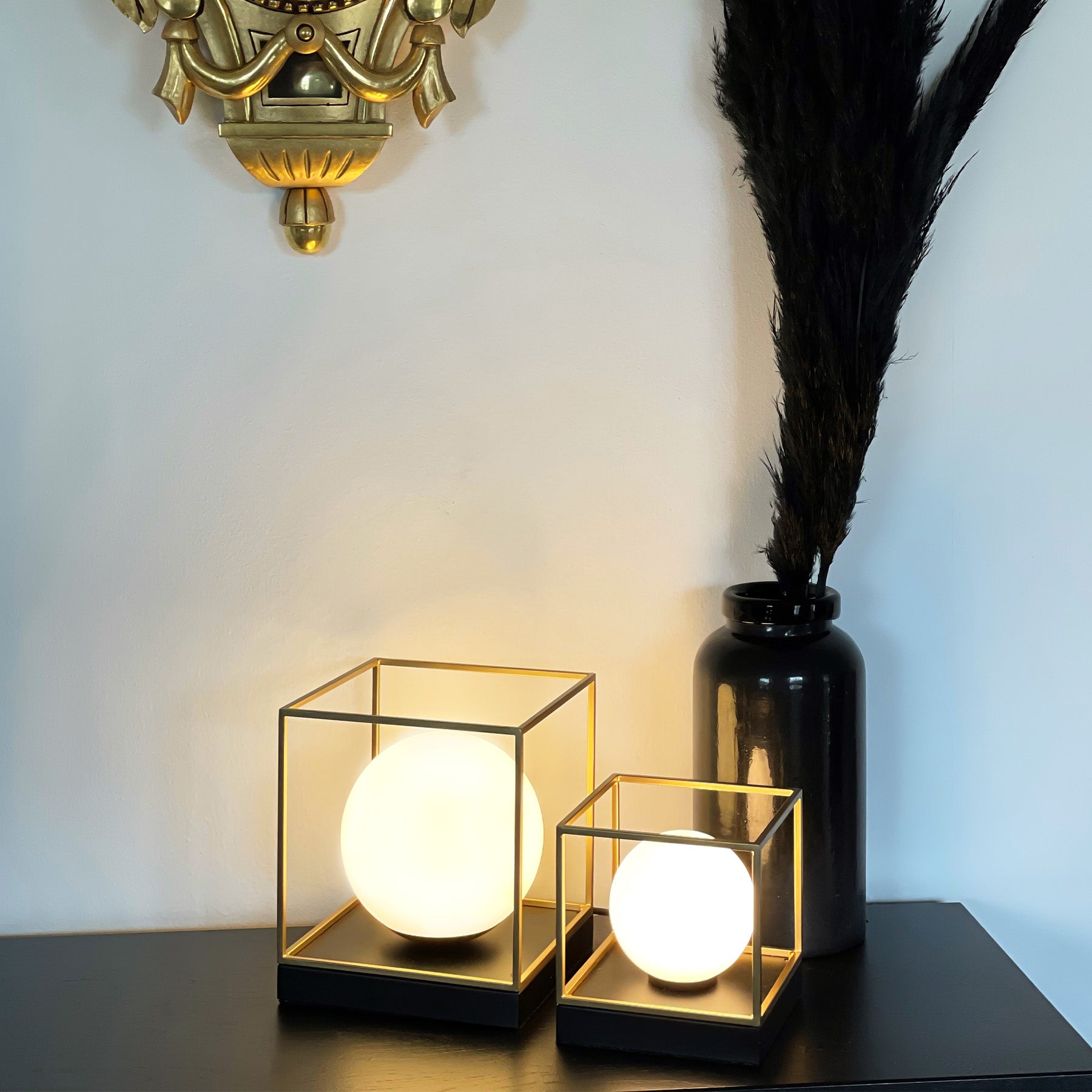 Interiørbilde av Astro firkantede bordlamper liten og stor med opal glasskuppel i en ramme i messing og svart metall - Aneta belysning
