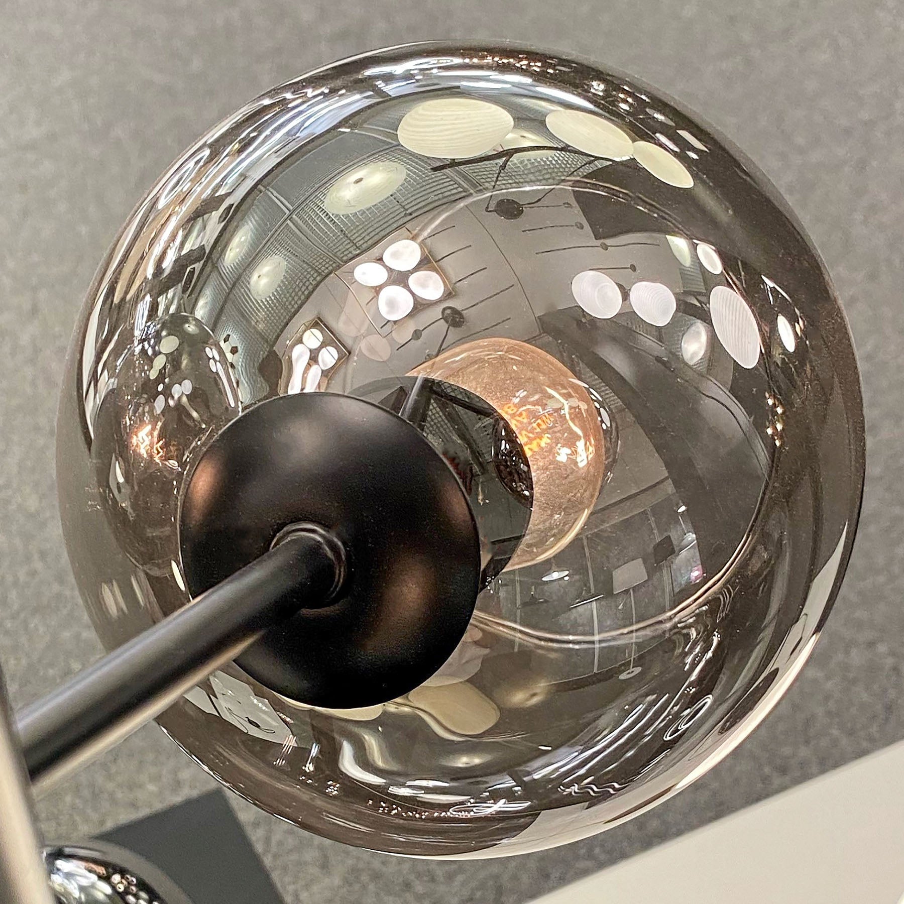Nærbilde av kuppel til Atom taklampe pendel med fem sotede glasskupler og sort metall E14 - Aneta Belysning