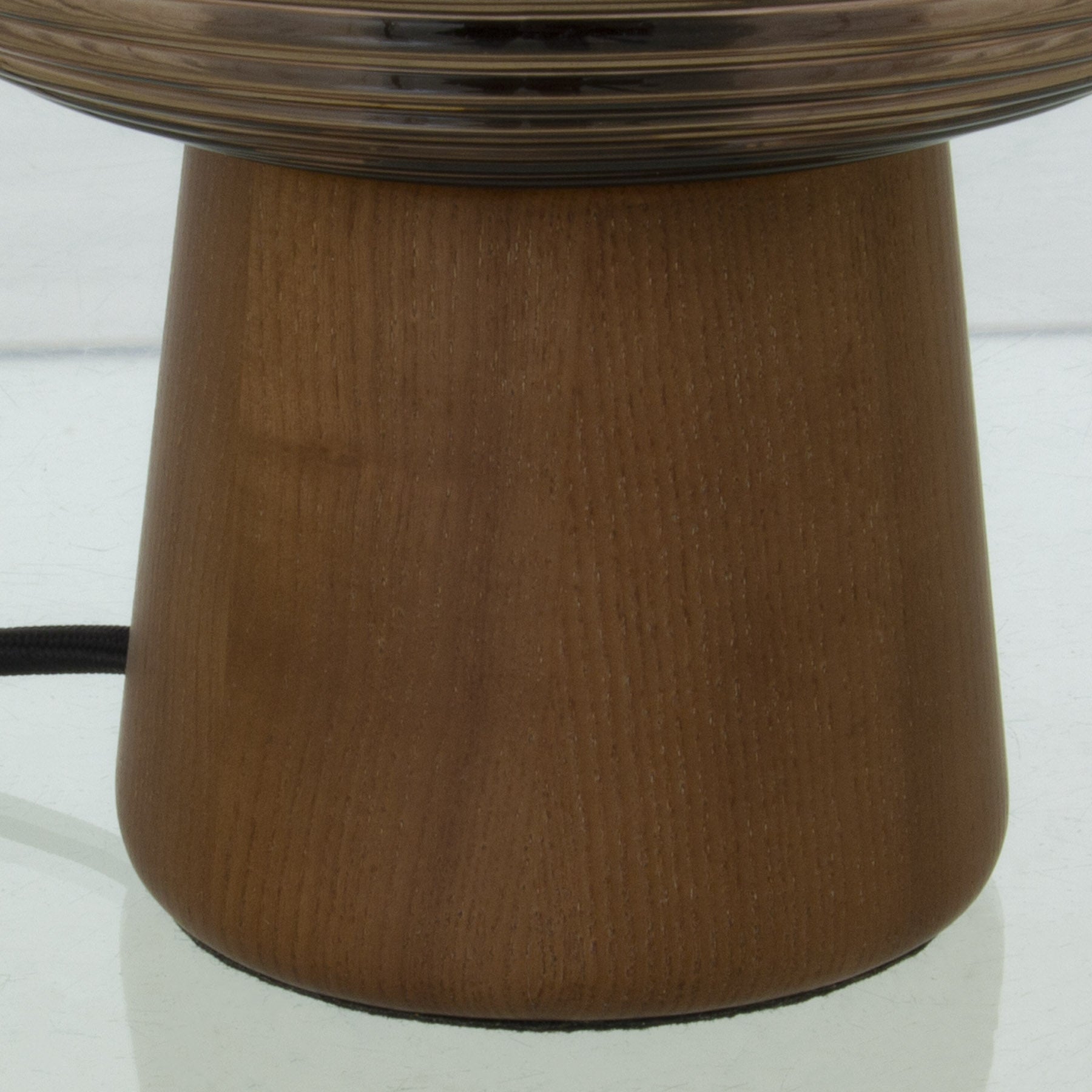 Nærbilde av fot til Aura bordlampe med brunbeiset lampefot i treverk og brun rillet glasskjerm rund- Aneta belysning