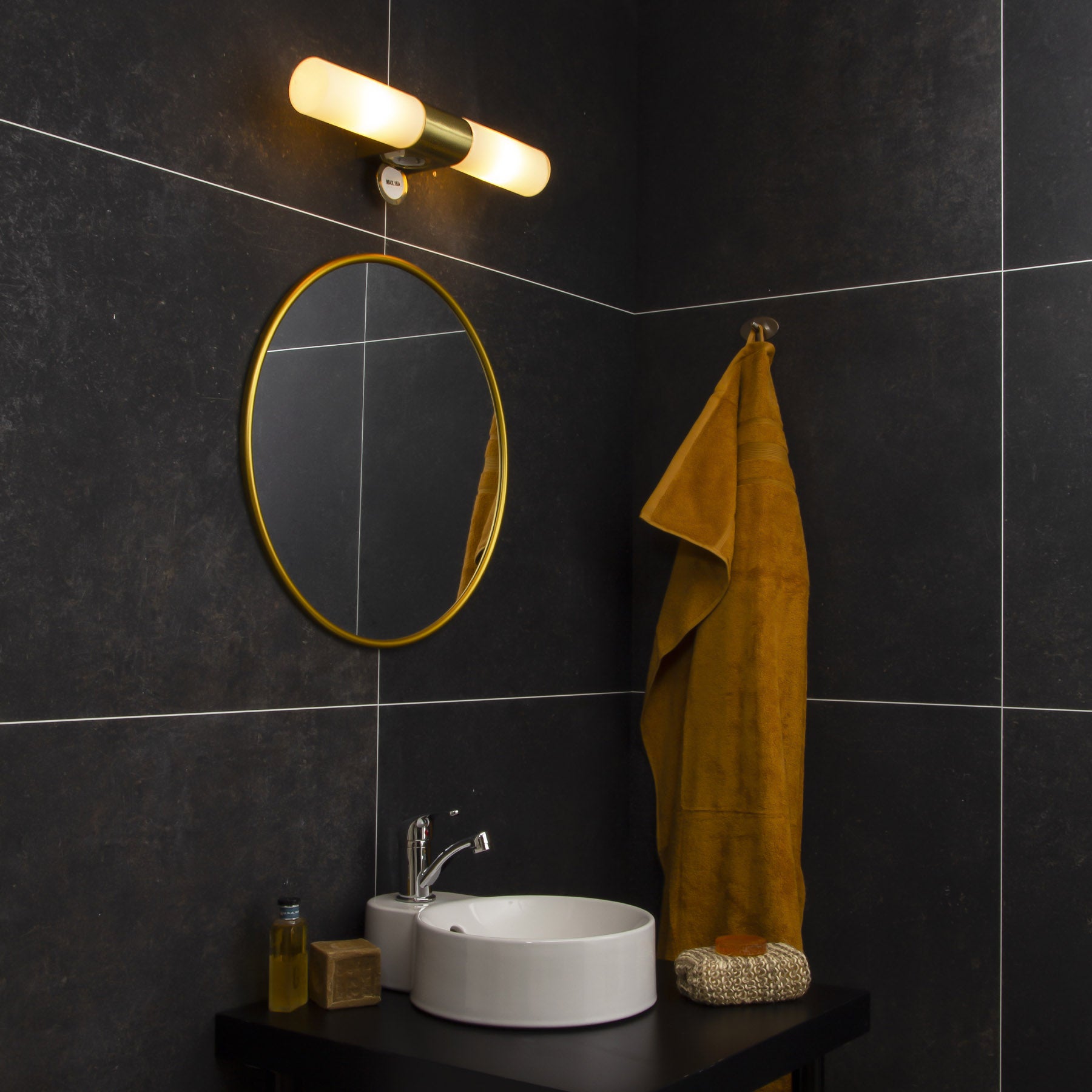 Interiørbilde av Cosenza vegglampe til badet laget i matt messing og opalglass. Lampen har uttak til stikkontakt og to sokler. IP44. Aneta belysning